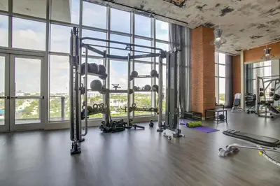 a gym with treadmills and machines in a room with windows at Upscale Condo with Pool Access in Hyde Beach House! in Hollywood