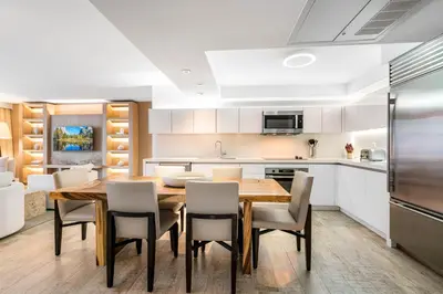 a kitchen and dining room with a wooden table and chairs at Oceanview Private Condo at 1 Hotel & Homes -1115 in Miami Beach