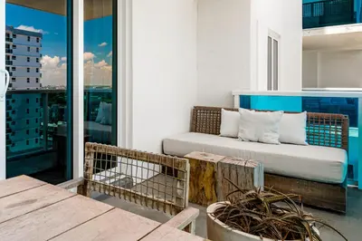 a couch on the balcony of a building at Oceanview Private Condo at 1 Hotel & Homes -1115 in Miami Beach