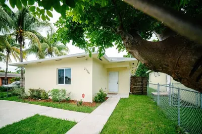 a white house with a tree in front of it at New house on the block near Miami Airport. in Miami