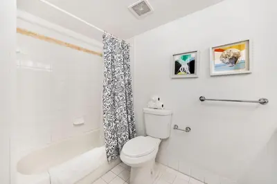 a white bathroom with a toilet and a bathtub at Brickell Apartments with Oceanview in Miami