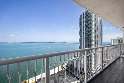a balcony with a view of the ocean and a tall building at Brickell Apartments with Oceanview in Miami