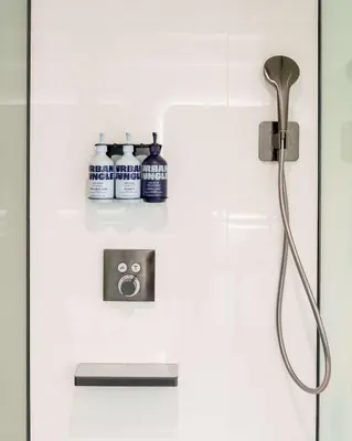 a shower in a bathroom with three bottles on the wall at YOTEL Miami in Miami