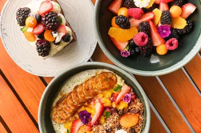 a table with three bowls of food and a plate of fruit at YOTELPAD Miami in Miami