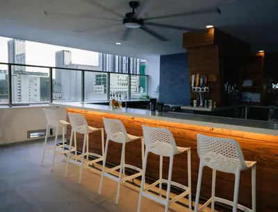 a row of white chairs sitting at a bar at YOTELPAD Miami in Miami