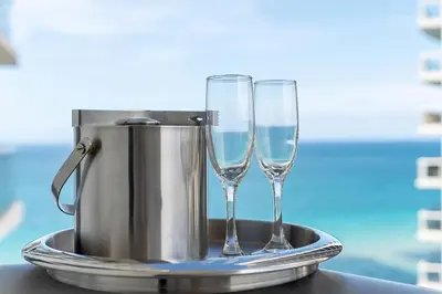 two wine glasses on a tray with a ice bucket at Sunny Isles 1BDR Sea View and Pool in Miami Beach