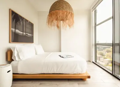 a bedroom with a white bed and a chandelier at Flow Hotel Fort Lauderdale in Fort Lauderdale