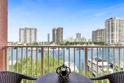 a table and chairs on a balcony with a view of the water at Yacht Club at aventura Amazing Marina view parking included in Miami