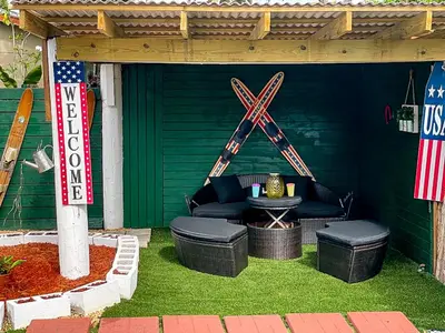 an outdoor patio with a table and chairs and an american flag at Hammocks & mini-golf! 10 mins from Beach! in Hollywood