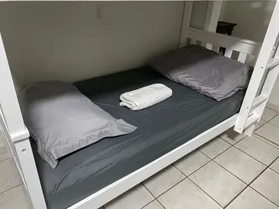 a bunk bed with two pillows on top of it at Single Size BOTTOM Bunk Bed - Mixed Shared ROOM in Miami