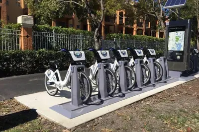 a row of bikes parked in a rack on a sidewalk at Renovated cozy The yacht club at aventura Parking included in Miami