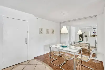 a white dining room with a table and chairs at Renovated cozy The yacht club at aventura Parking included in Miami