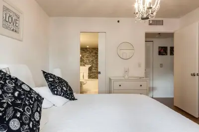 a bedroom with a white bed and a chandelier at Renovated cozy The yacht club at aventura Parking included in Miami