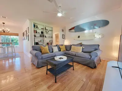 a living room with a couch and a surfboard on the wall at Surf House - Paddleboards - Canoes -1 mile to Wilton Manors in Fort Lauderdale