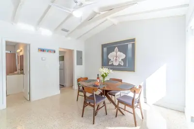a dining room with a wooden table and chairs at Renovated Apts with Kitchen, Fast WiFi, Smart TV, Roku & Pool Onsite 4 mi to Surfside Beach in North Miami