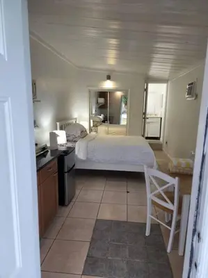 a bedroom with a bed and a desk and a kitchen at 13101 Main Apartment Miami in Miami