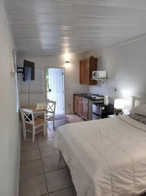 a bedroom with a bed and a table and a kitchen at 13101 Main Apartment Miami in Miami
