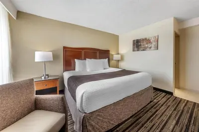 a hotel room with a bed and a chair at Best Western Plus North Miami-Bal Harbour in North Miami
