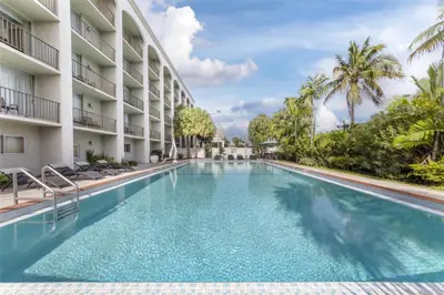 a swimming pool at a resort with palm trees at Best Western Plus North Miami-Bal Harbour in North Miami