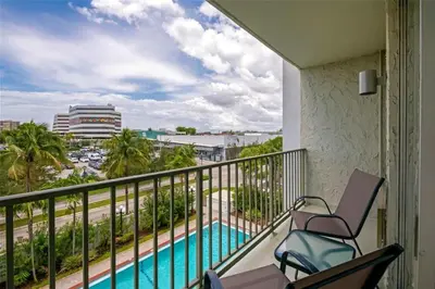a balcony with two chairs and a swimming pool at Best Western Plus North Miami-Bal Harbour in North Miami