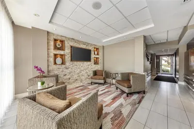 a lobby with couches and a tv on a brick wall at Best Western Plus North Miami-Bal Harbour in North Miami