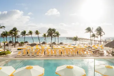a view of the beach from the balcony of a resort with umbrellas at The Sunny in Sunny Isles Beach