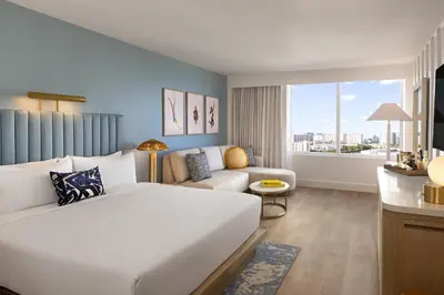 a hotel room with a large bed and a couch at The Sunny in Sunny Isles Beach