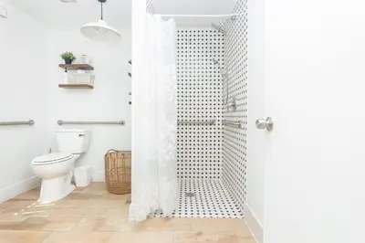 a white bathroom with a shower with a toilet at West Deco in Miami Beach