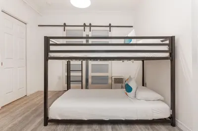 a bedroom with a bunk bed with white sheets at West Deco in Miami Beach