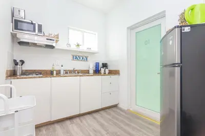 a kitchen with white cabinets and a refrigerator at West Deco in Miami Beach