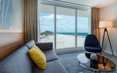 a living room with a couch and a view of a beach at B Ocean Resort Fort Lauderdale Beach in Fort Lauderdale