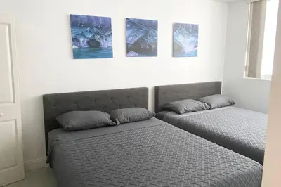 two beds in a room with paintings on the wall at Comfortable 2 BR at Brickell , Free Parking in Miami