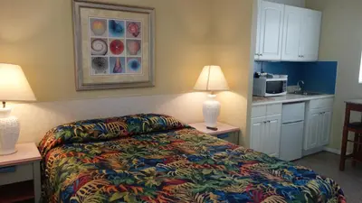 a bedroom with a bed and a kitchen with a microwave at Ocean Inn in Hollywood