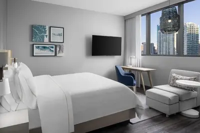 a white bedroom with a bed and a chair and a tv at Element Miami Brickell in Miami