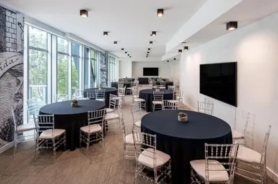 a room with tables and chairs and a flat screen tv at Atwell Suites Miami Brickell by IHG in Miami