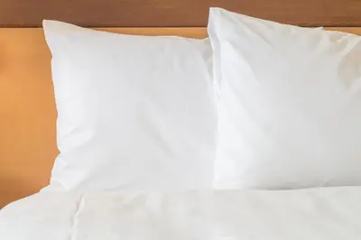 a bed with white sheets and pillows on it at Atwell Suites Miami Brickell by IHG in Miami
