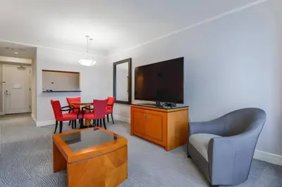 a living room with a television and a table with chairs at Live the Miami Experience in an Exclusive Condo 4S in Miami