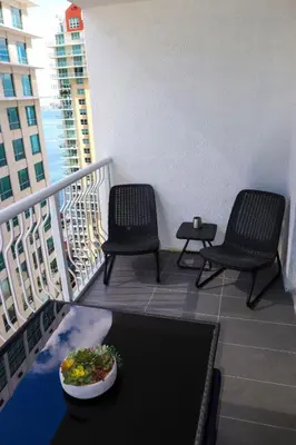 a balcony with two chairs and a plate of food on it at Luxury Accommodations Brickell in Miami