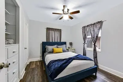 a bedroom with a blue bed with a ceiling fan at Home wworkstation by PMI unit 2908 in Hollywood