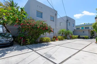 a car parked in front of a building with flowers at Sunny Days Apartments in Miami Beach