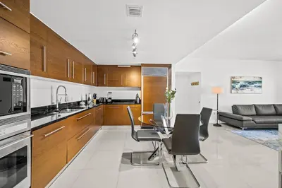 a kitchen and living room with a table and chairs at *ICONIC W ICON CONDO/ POOL&WATERVIEWS*FREESPA* in Miami