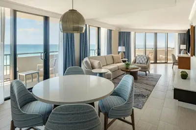 a living room with a couch and a table and chairs at Fort Lauderdale Marriott Harbor Beach Resort & Spa in Fort Lauderdale