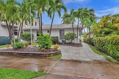 a house with palm trees and a driveway at SuperVilla - 3BR/2BA - Pool - Walk to beach in Hollywood