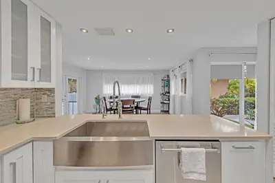 a kitchen with a sink and a dining room at SuperVilla - 3BR/2BA - Pool - Walk to beach in Hollywood