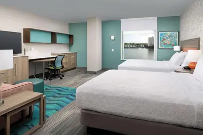 a hotel room with two beds and a desk at Home2 Suites By Hilton Miami Airport South Blue Lagoon in Miami