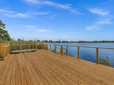 a wooden dock with a bench on top of the water at SuperVilla - Lakefront - Sunsets, Kayaks, Grill in Fort Lauderdale