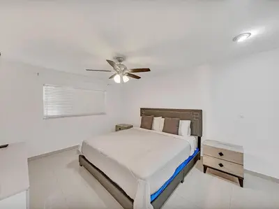 a white bedroom with a bed and a ceiling fan at SuperVilla - Lakefront - Sunsets, Kayaks, Grill in Fort Lauderdale