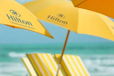two yellow umbrellas and some books on the beach at Hilton Cabana Miami Beach Resort in Miami Beach