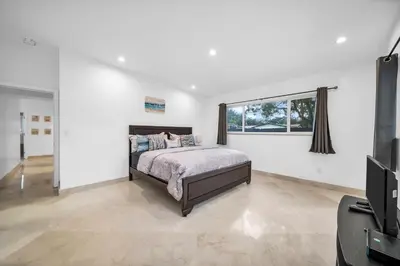 a bedroom with a bed and a flat screen tv at Pool Villa in Miami