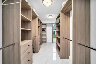a walk in closet with wooden cabinets at Pool Villa in Miami